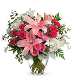 Pink lilies and roses in a clear glass vase