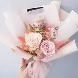 Pink and cream rose bouquet wrapped in pale paper