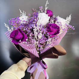 Bouquet of purple and white roses with small purple filler flowers