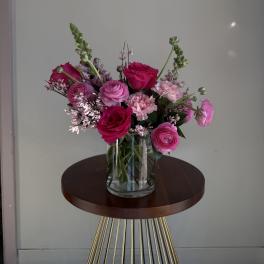 Pink and magenta flowers arranged in a clear glass vase