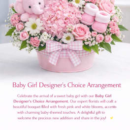 Pink and white baby girl flower arrangement with a teddy bear and booties