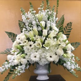 White floral arrangement in a white pedestal vase