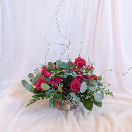 Red roses in a rustic birch container with eucalyptus