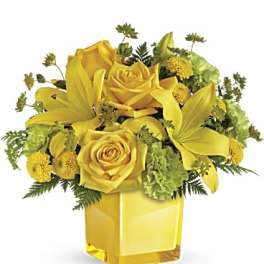 Yellow roses and lilies arranged in a square glass vase
