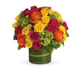 Bright mixed rose bouquet in a green glass vase