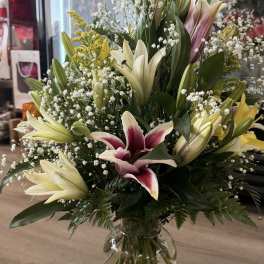 Large bouquet of lilies and baby's breath in a clear glass vase