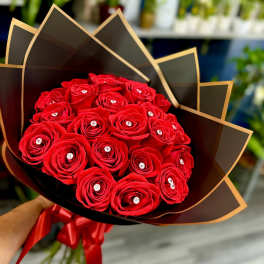 Bouquet of red roses wrapped in black paper with a red ribbon