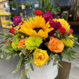 Bright mixed bouquet with sunflowers, roses, and chrysanthemums in a white box