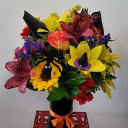 Colorful bouquet with sunflowers and lilies in a black vase