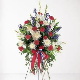 Standing floral spray with red, white, and blue flowers on an easel