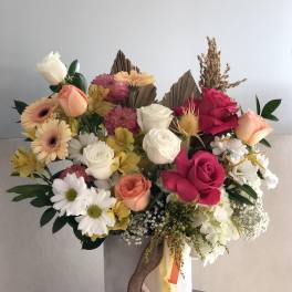 Mixed bouquet of roses, daisies, and gerbera daisies in a tall box