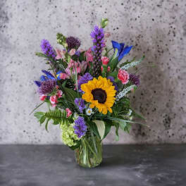 Mixed bouquet with a sunflower in a glass vase