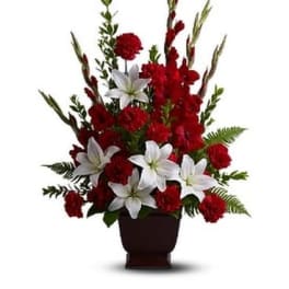 Red and white floral arrangement in a dark vase