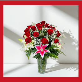 Red roses and pink lilies in a clear glass vase
