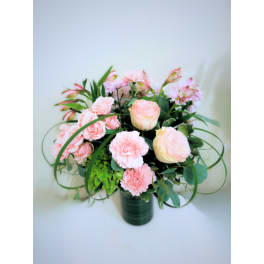 Pink roses and carnations in a dark green vase