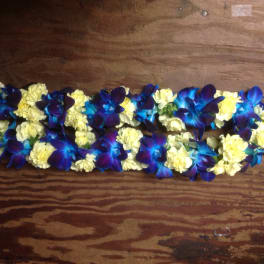 Blue orchids and pale yellow carnations arranged in a long garland