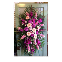 Tall pink and peach floral standing spray with palm fronds