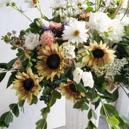 Large bouquet of white daisies, sunflowers, and pale pink blooms