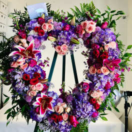 Heart-shaped floral wreath with pink, purple, and red blooms