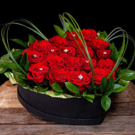 Red roses arranged in a black heart-shaped box