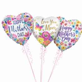 Three heart-shaped Mother's Day balloons with floral prints and pink ribbons