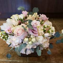 Soft pink and white bouquet with roses and eucalyptus in a low container