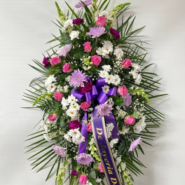 Standing floral spray with pink, white, and lavender flowers on an easel