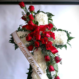 Standing funeral spray of red roses and white carnations with a memorial ribbon