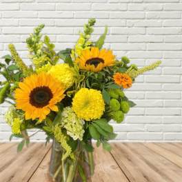 Sunflowers and yellow blooms in a glass vase