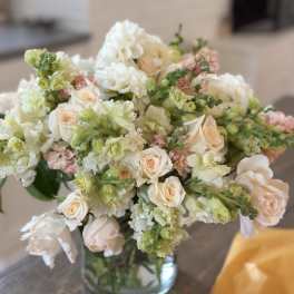 Bouquet of pale roses and white snapdragons in a glass vase
