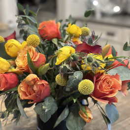 Orange and yellow rose bouquet in a black vase