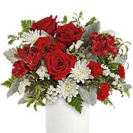 Red roses, red carnations, and white mums arranged in a white cylinder vase