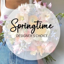 Person holding a pastel mixed flower bouquet with a "Springtime" label