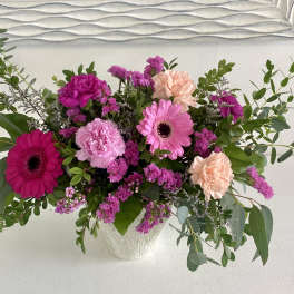 Pink and peach mixed flower arrangement in a white vase