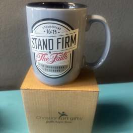 Gray mug with a faith message sitting on a cardboard box