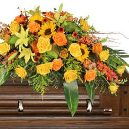 Yellow and orange floral spray on a wooden casket