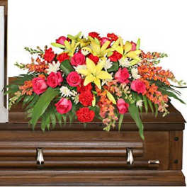 Bright floral spray arranged on a wooden casket
