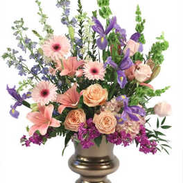 Mixed pink, purple, and peach flowers in a gold vase