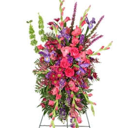 Tall standing arrangement of pink and purple flowers on an easel