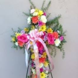 Standing floral spray with pink roses and multicolored daisies on an easel