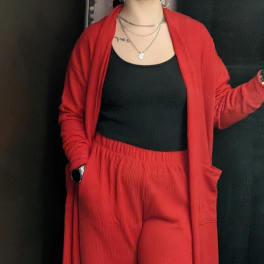 Person wearing a red cardigan and matching pants over a black top