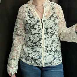 Person wearing a sheer floral lace button-up top with long sleeves