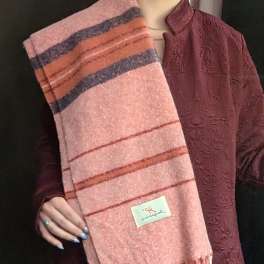 Person holding a pink striped scarf with fringe