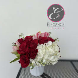 Red roses and white hydrangeas in a white vase