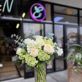 Bouquet of white and pale green flowers in a clear glass vase