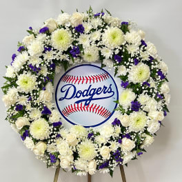 Large white floral wreath on an easel with a Dodgers logo in the center
