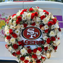 Large red and white floral wreath on a stand