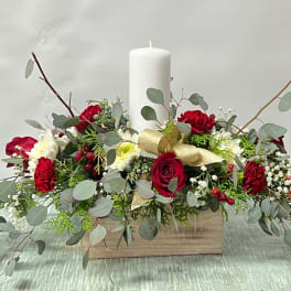 Red and white floral centerpiece with a white pillar candle