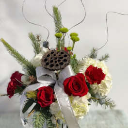 Red roses and white hydrangeas in a vase with a silver ribbon