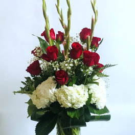 Tall bouquet of red roses and white hydrangeas in a glass vase